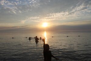 Sunset at Camp Huron showing young campers in the water