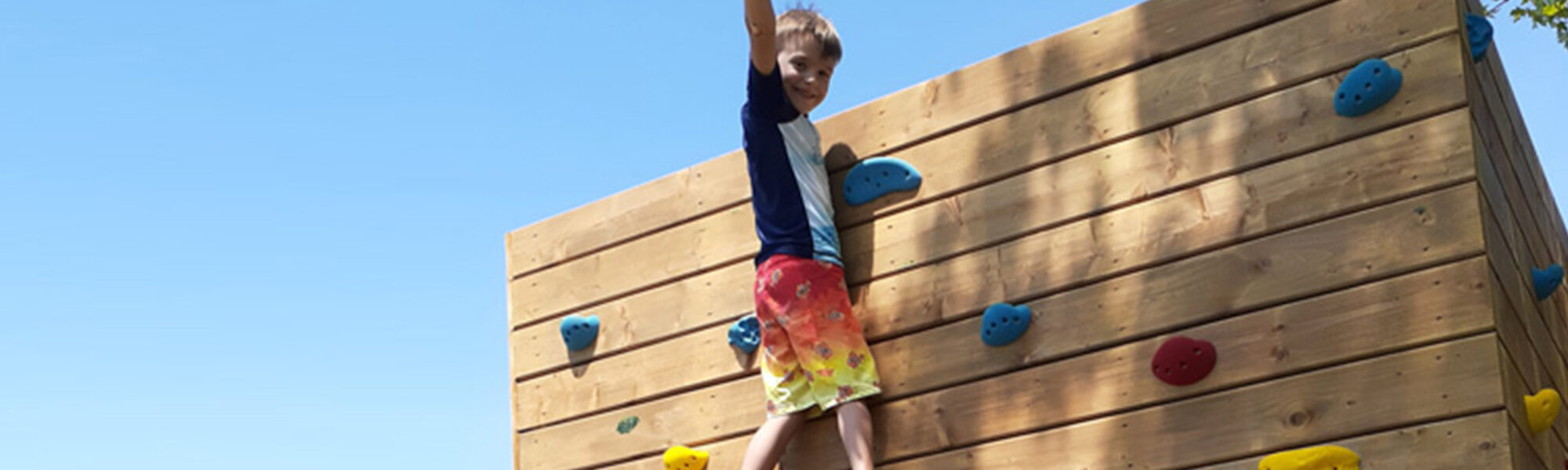 camper at the top of the climbing wall