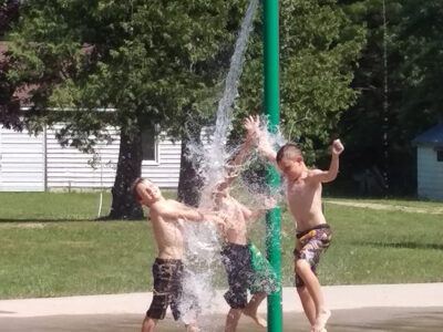 Three young campers splashing around the Camp Huron water park.